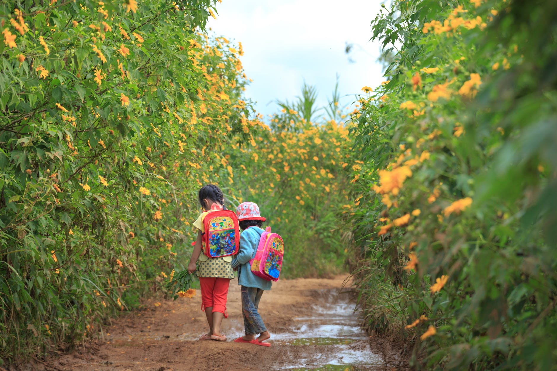 photo of kids walking on dirt road