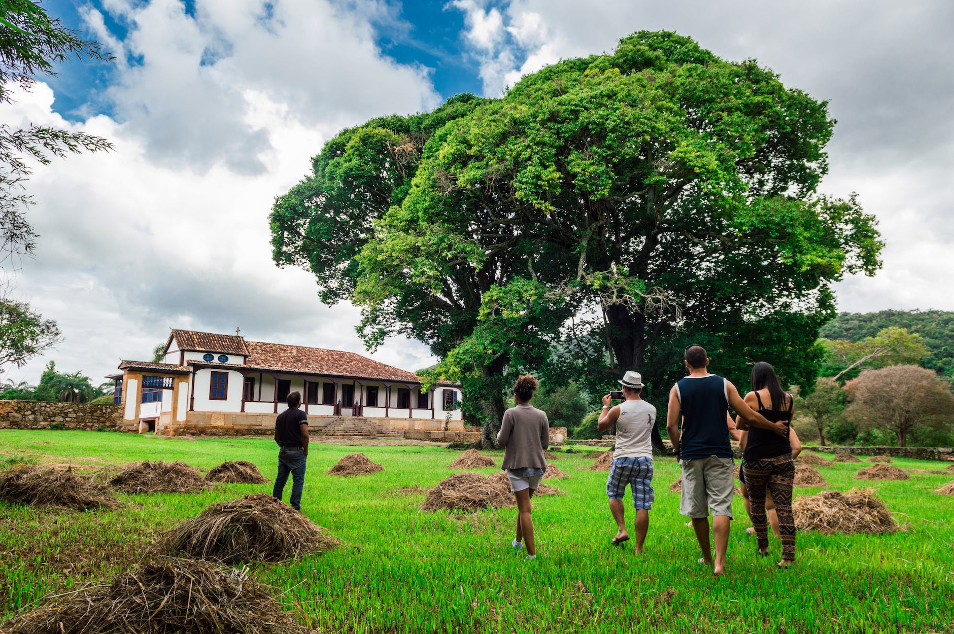 group of people walking along green grass field